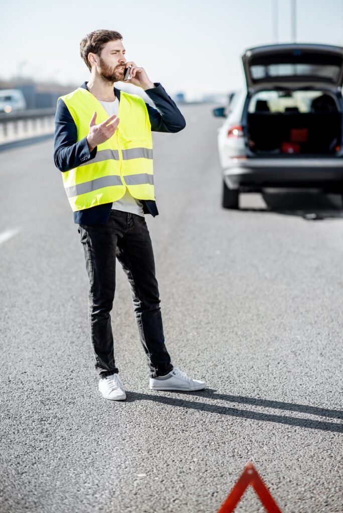 Man calling road assistance on the highway